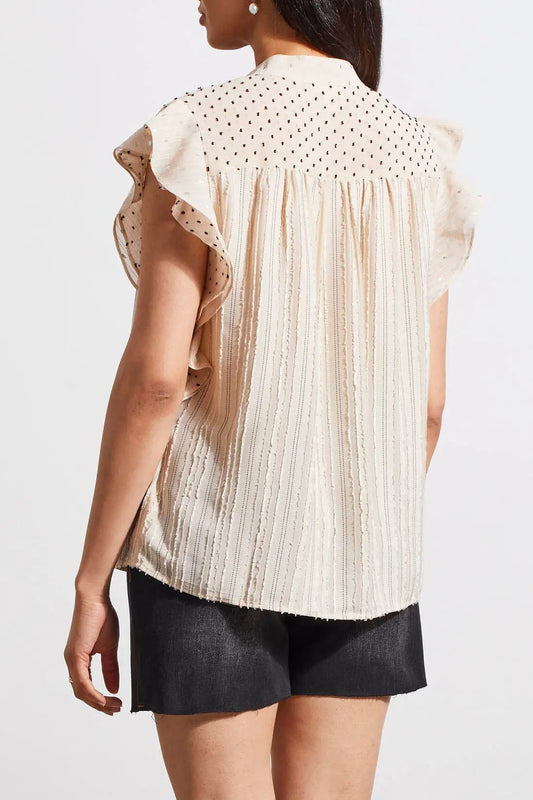 A woman modeling a sophisticated outfit with a Tribal mixed media blouse featuring frill sleeves, denim shorts, and black espadrille sandals.