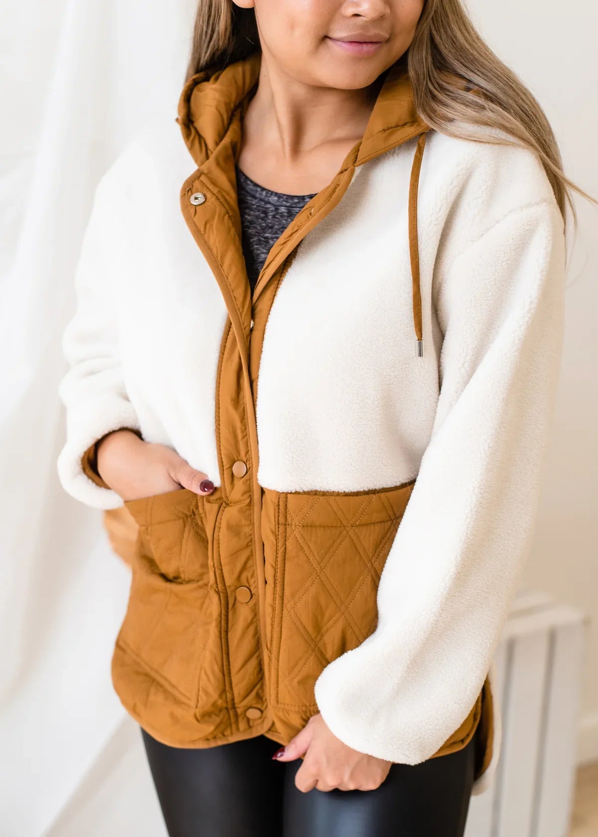 A woman wearing a cozy Molly Bracken Woven 2 Tone Sherpa Jacket for warmth and comfort.