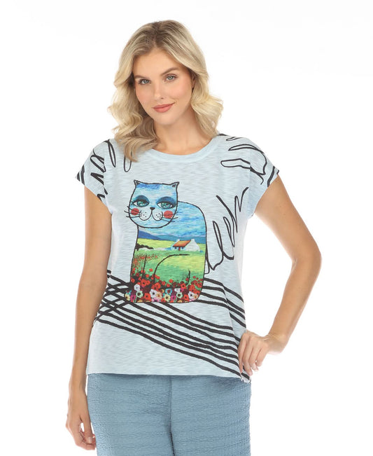 A woman faces away, wearing the Inoah Short Sleeve Crew Neck Top in light blue, featuring a cat silhouette with a house, field, sky, and flowers on the back.