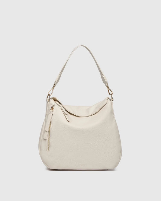 The Louenhide NADIA SHOULDER BAG is cream-colored, crafted from vegan leather with a single shoulder strap, gold-tone hardware, and a side zipper tassel, shown on a plain light background.