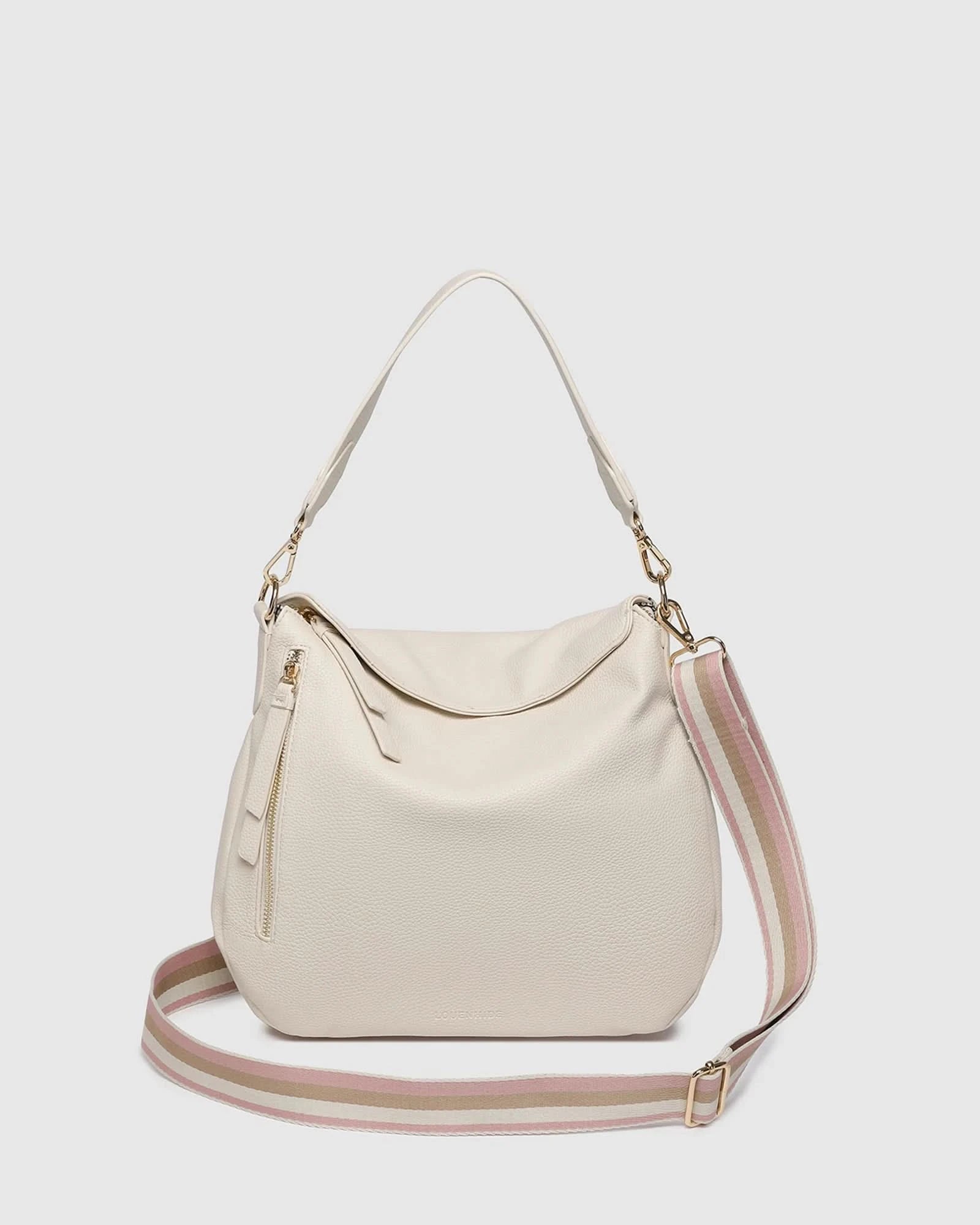 The Louenhide NADIA SHOULDER BAG is cream-colored, crafted from vegan leather with a single shoulder strap, gold-tone hardware, and a side zipper tassel, shown on a plain light background.