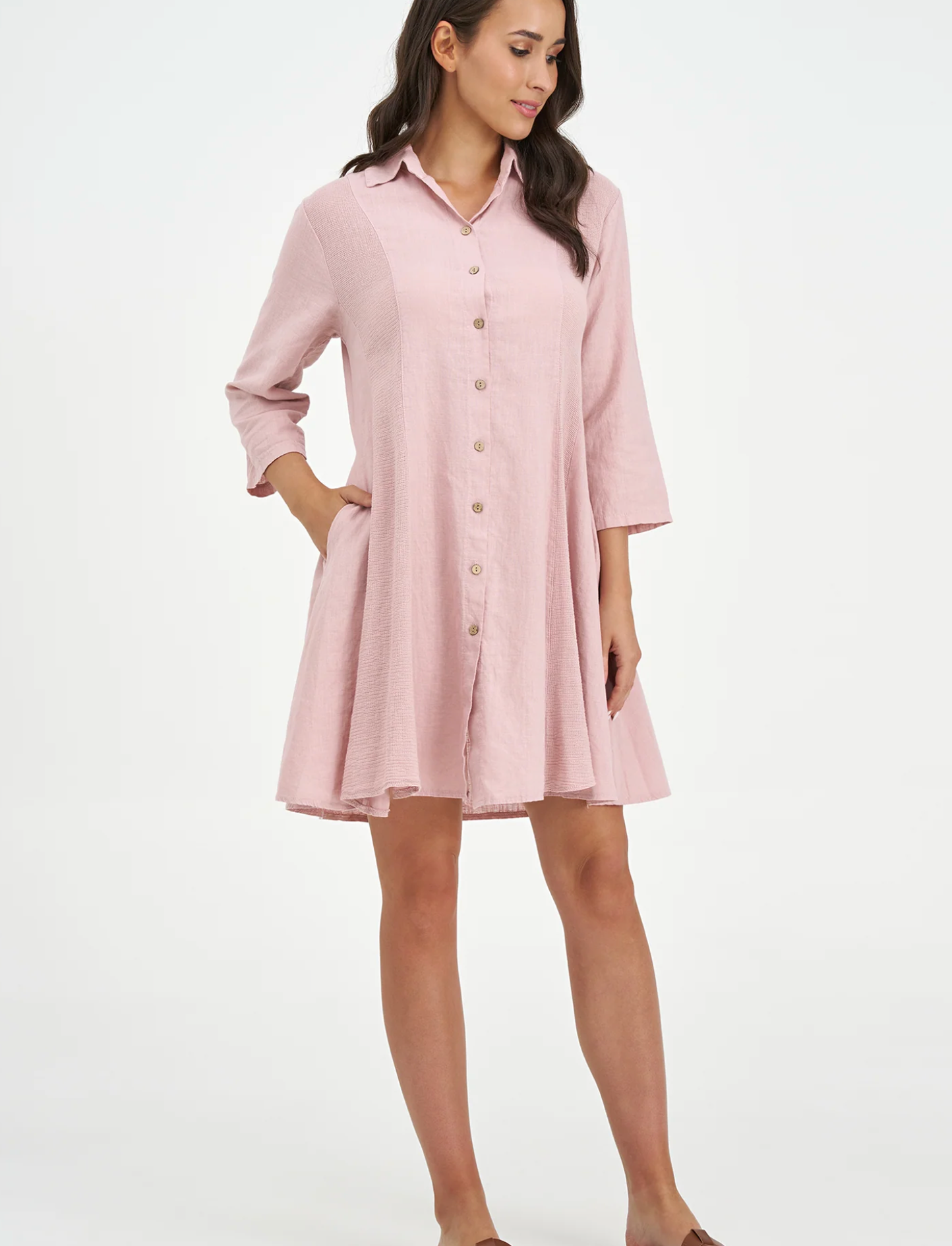 A woman models the M Made In Italy "Made in Italy Dress," a light pink, collared linen dress with three-quarter sleeves—perfect for elevating your spring wardrobe.
