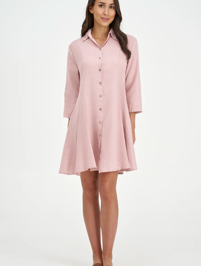 A woman models the M Made In Italy "Made in Italy Dress," a light pink, collared linen dress with three-quarter sleeves—perfect for elevating your spring wardrobe.