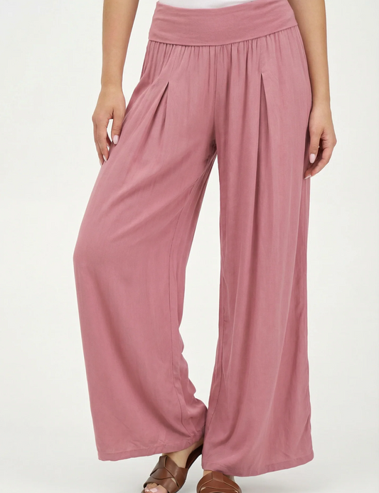 A person wearing mauve Made in Italy knit pants by M Made In Italy with a high waist and pleats, paired with brown sandals.