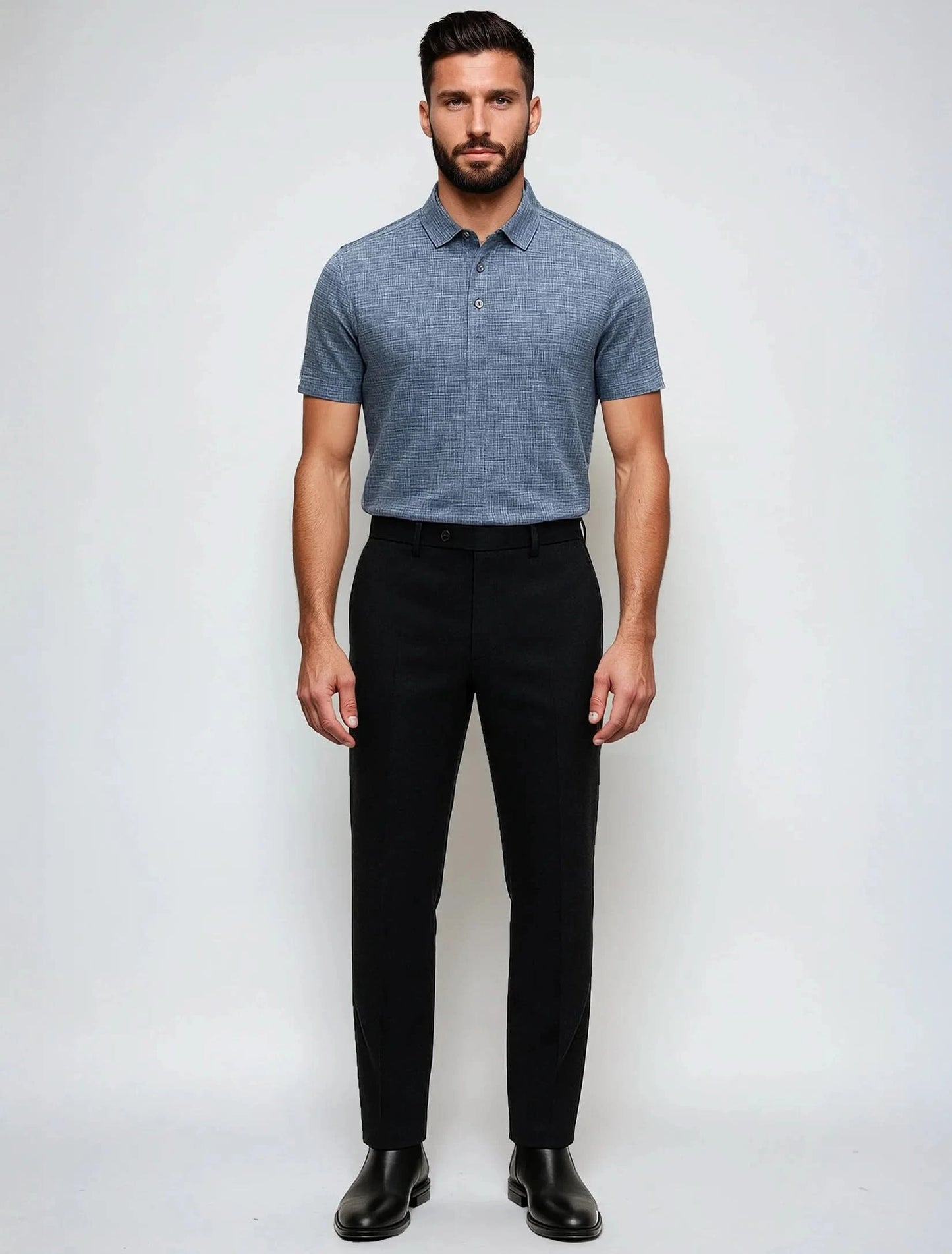 A man stands facing forward, wearing a Point Zero Mens Jersey Polo in blue, black dress pants, and black shoes against a plain white background.