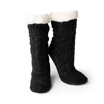 A woman sitting on a chair wearing Cray Cray Soft Slipper Socks, the slip-proof chenille fuzzy socks from Britt's Knits.