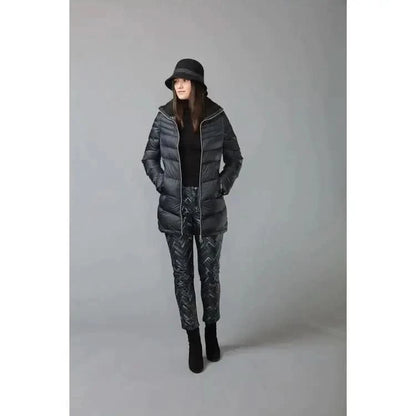 A woman wearing a black puffer jacket and pants, sporting an iconic Claude - Small Bell Hat from Canadian Hat, from Montreal.