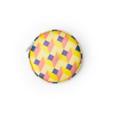 A person is using an In A Fix mini tape measure to place a piece of paper on a wooden table.