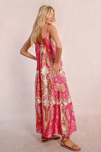 Against a plain light background, an elegant person with long hair is seen wearing a Satin Dress With Straps by Molly Bracken, along with brown sandals.