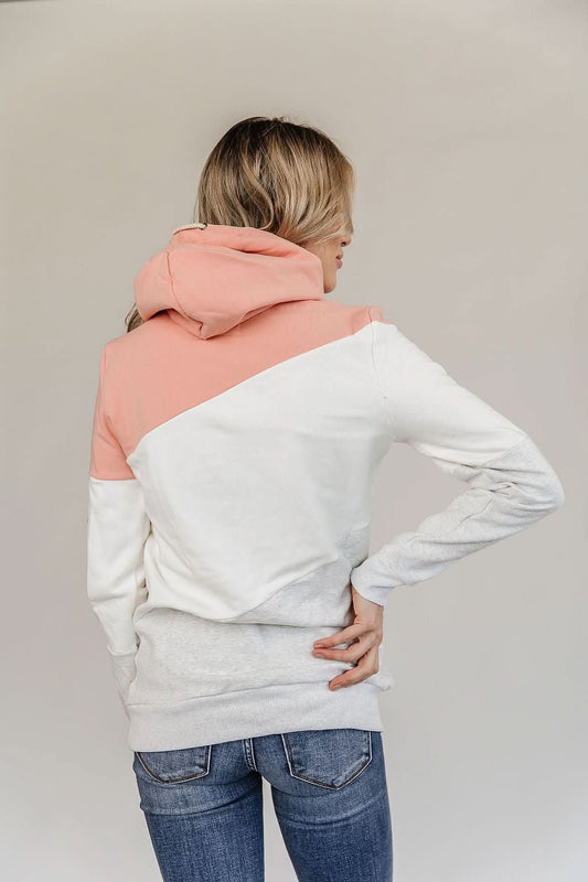 Clad in the cozy, color-blocked Be Fearless Singlehood Sweatshirt by Ampersand Avenue, featuring a harmonious blend of pink, white, and gray tones, a person stands confidently against a plain background. Paired with blue jeans, this sweatshirt effortlessly captures the essence of style and independence.