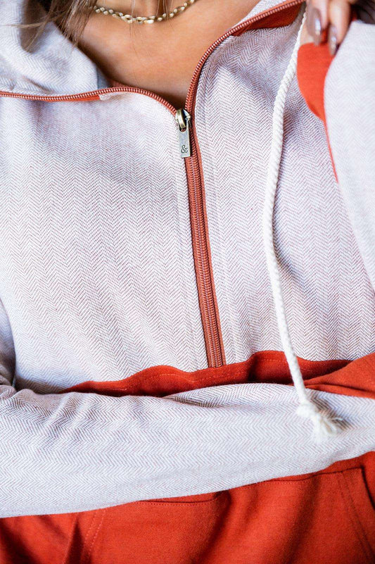 A person wearing The Bright Side - Two Tone Half Zip Sweatshirt by Ampersand Avenue along with blue jeans and a rust bottom, smiling with closed eyes.