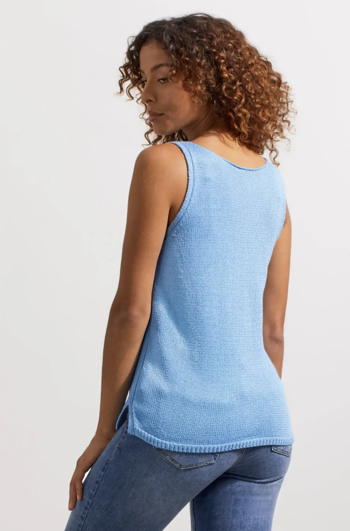 A woman wearing a Tribal sleeveless cable knit sweater.