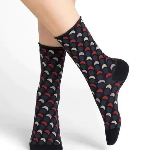 A woman's legs with orange and brown patterned 6362 socks from Bleuforet, made of 97% cotton and available in one size.