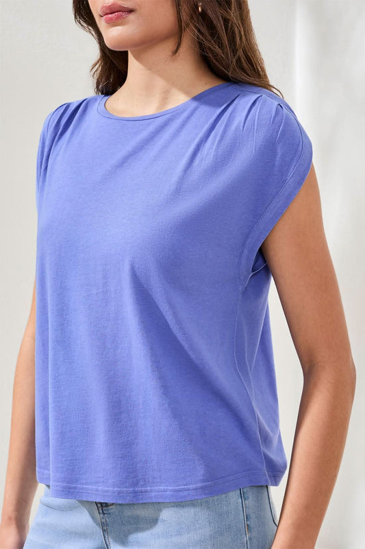 A woman wears the Tribal Boatneck cap sleeve top in purple, featuring pleated shoulders and a loose cotton blend fit, paired with light blue jeans against a neutral background.