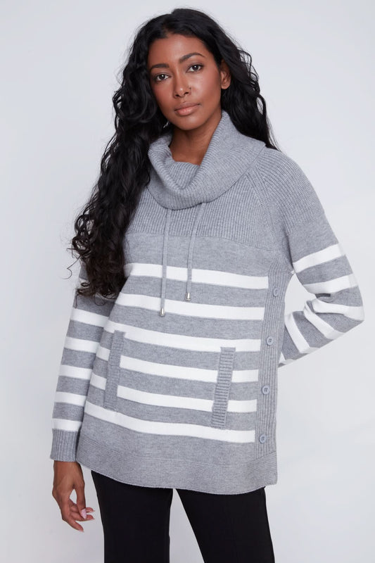 A woman models the CoCo Y Club Knitted Sweater, showcasing gray and white stripes, a cowl neck, front pockets, and side button details against a plain light background.