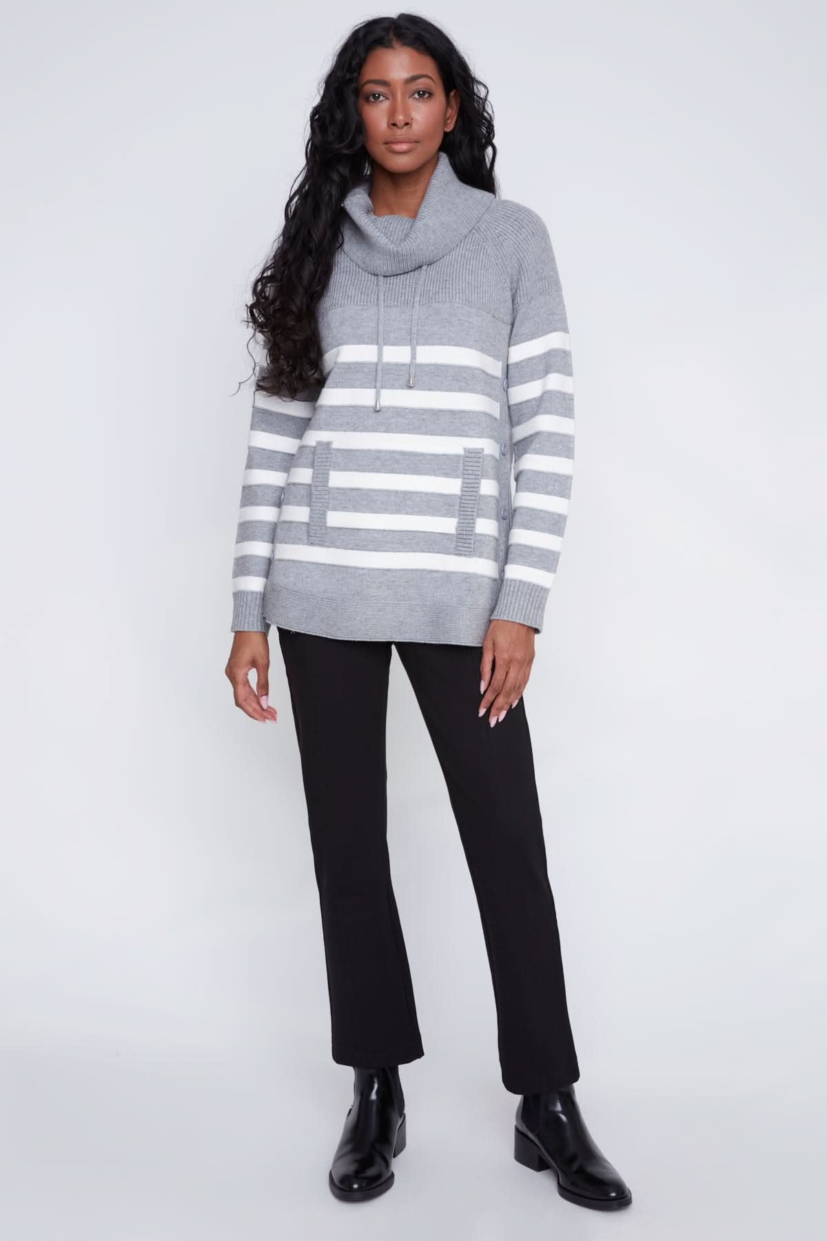 A woman models the CoCo Y Club Knitted Sweater, showcasing gray and white stripes, a cowl neck, front pockets, and side button details against a plain light background.