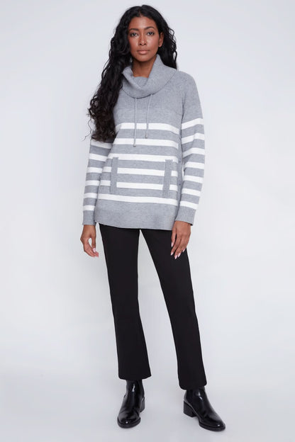 A woman models the CoCo Y Club Knitted Sweater, showcasing gray and white stripes, a cowl neck, front pockets, and side button details against a plain light background.