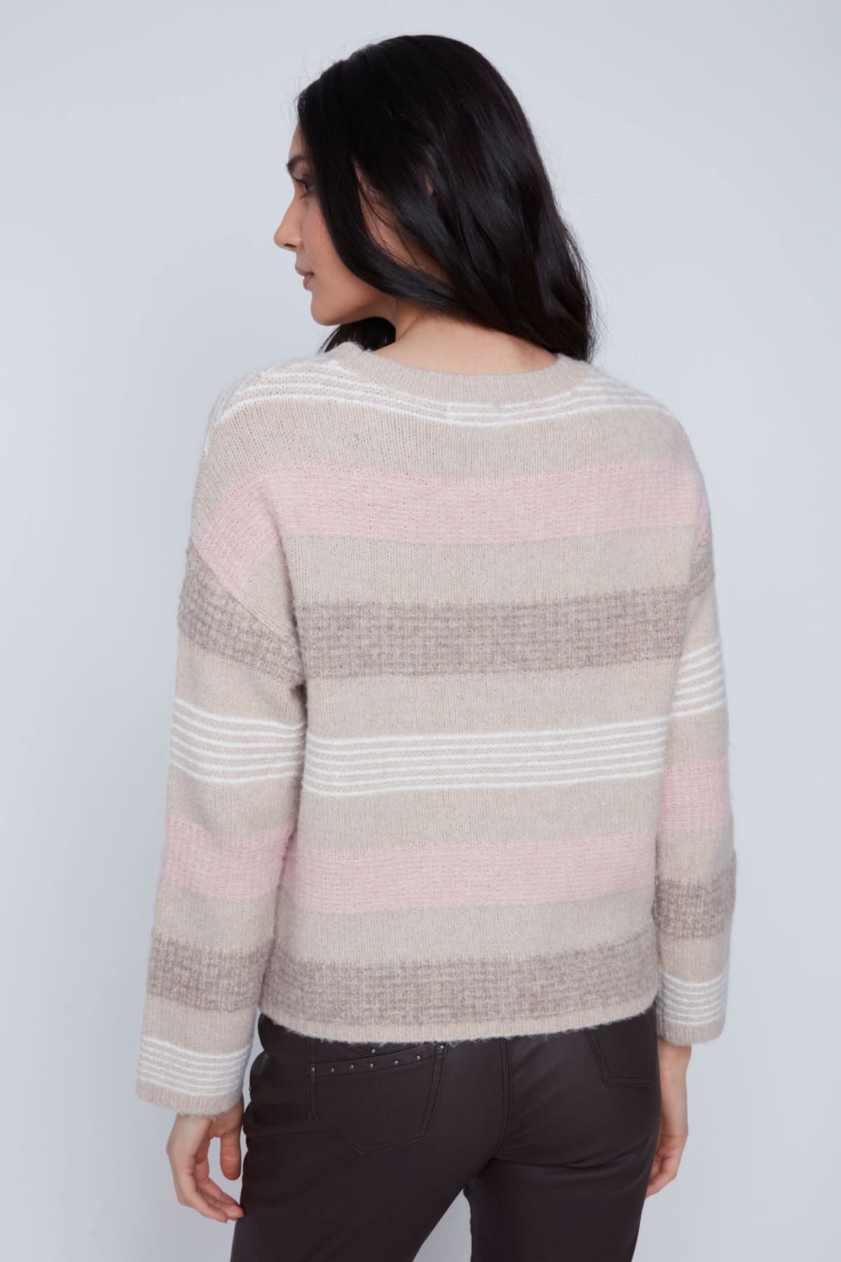A woman stands against a plain background wearing the CoCo Y Club Stripped Knitted Sweater, paired with dark pants and black ankle boots.