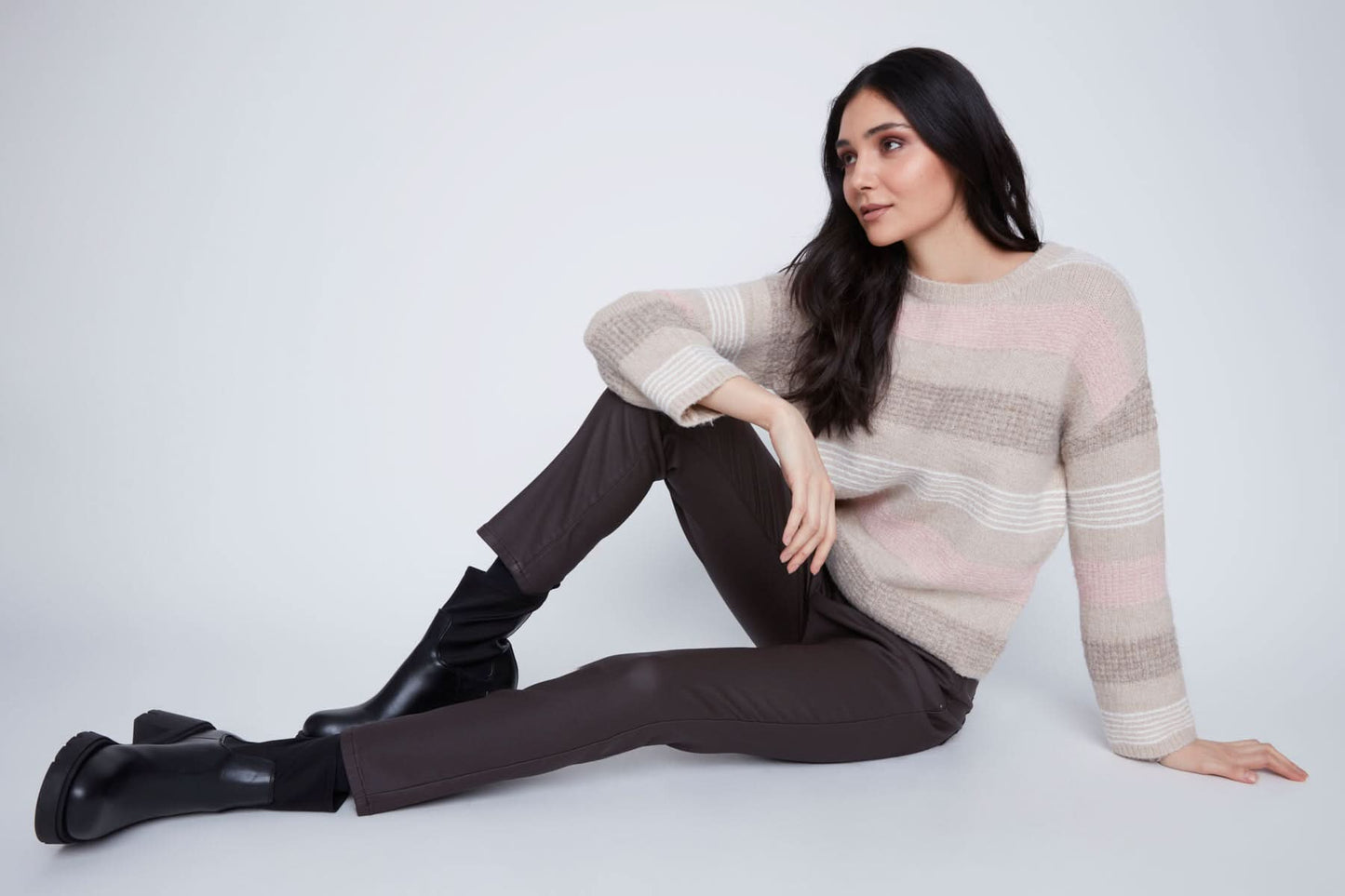 A woman stands against a plain background wearing the CoCo Y Club Stripped Knitted Sweater, paired with dark pants and black ankle boots.