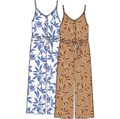 A woman models the Tribal Blue Flowy Jumpsuit, a sleeveless cotton style with blue leaf prints, button front, and a tied waist, standing indoors against a light background to showcase its chic silhouette.