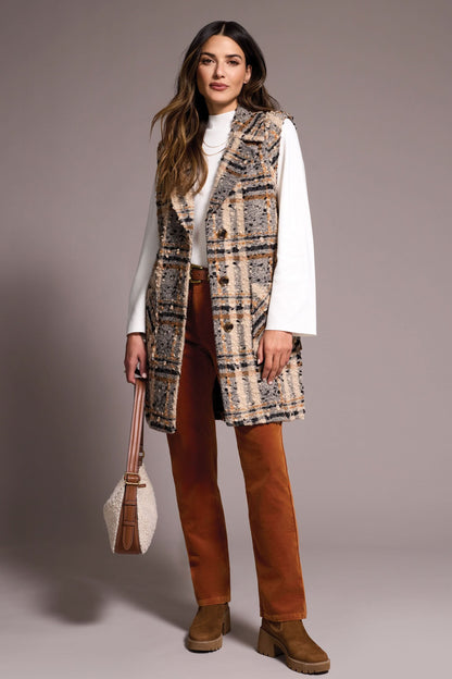 A woman models the Tribal WIDE NOTCH COLLAR VEST—a plaid, sleeveless coat with a wide notch collar—layered over a white turtleneck, rust pants, and brown boots while holding a handbag against a plain background.