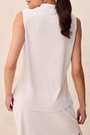 A woman models the Tribal TEXTURED QUARTER ZIP, a sleeveless white top with a high mock neck and quarter zip, shown from shoulders to mid-torso.