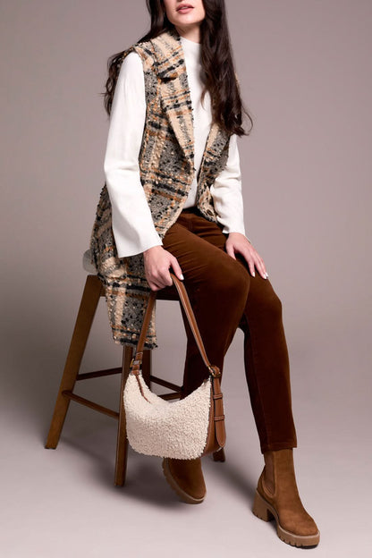 A woman models the Tribal WIDE NOTCH COLLAR VEST—a plaid, sleeveless coat with a wide notch collar—layered over a white turtleneck, rust pants, and brown boots while holding a handbag against a plain background.