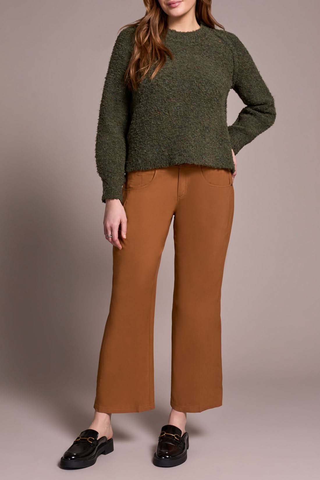 A woman wears brown pants and a Tribal Knit Crewneck Sweater Ivy.