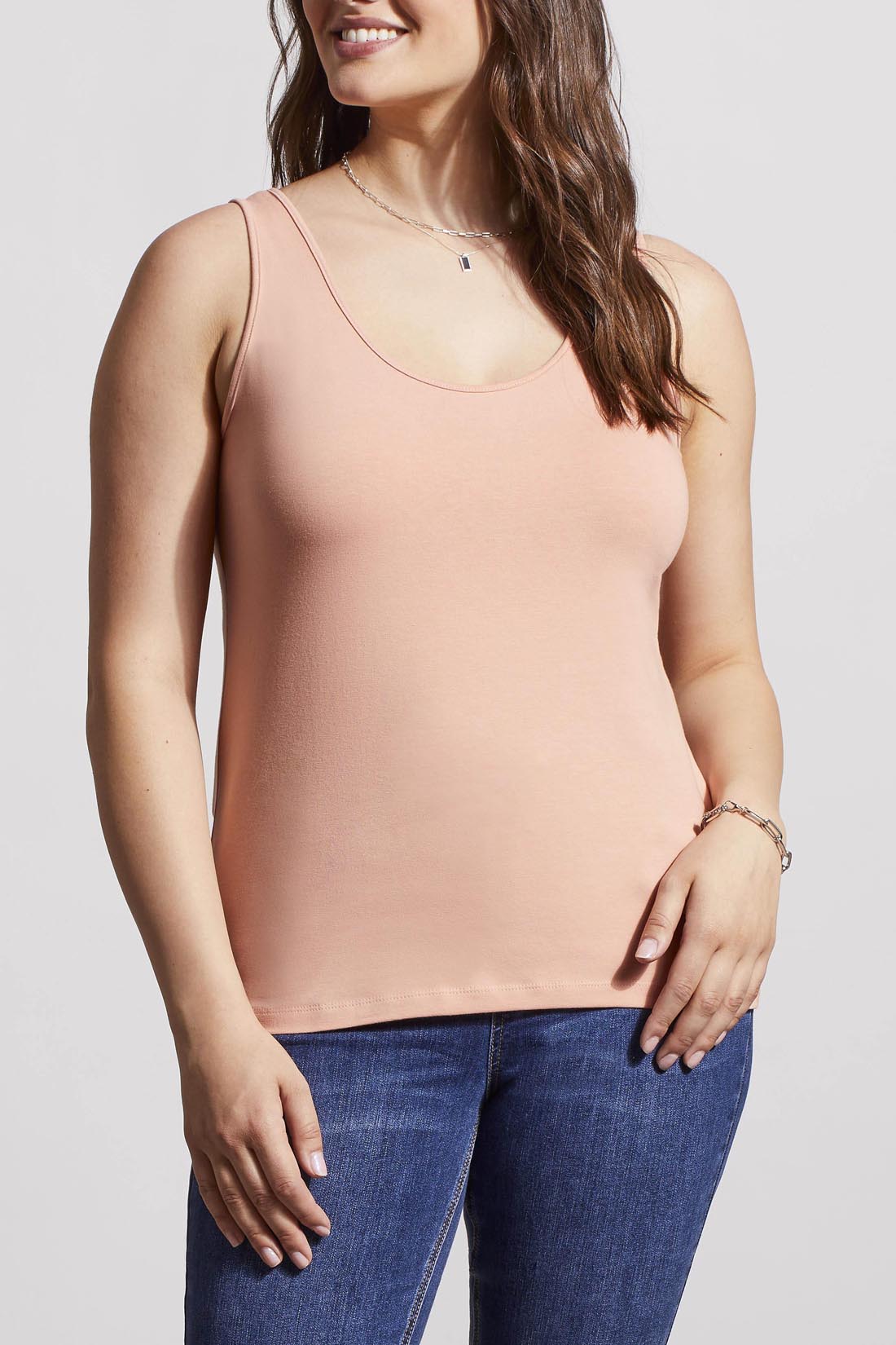 A woman in a cream Tribal Two Way Camisole and blue jeans, standing with one hand partially in her pocket.