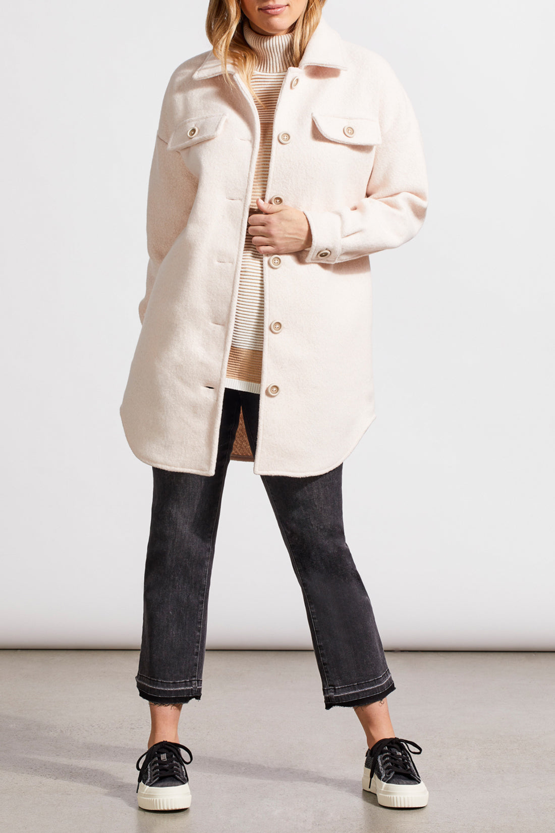 An individual with light hair is wearing a pale cream Stretch Boiled Wool Jacket by Tribal, featuring double-breasted button details. They are also dressed in a ribbed turtleneck sweater and are positioned against a plain background.