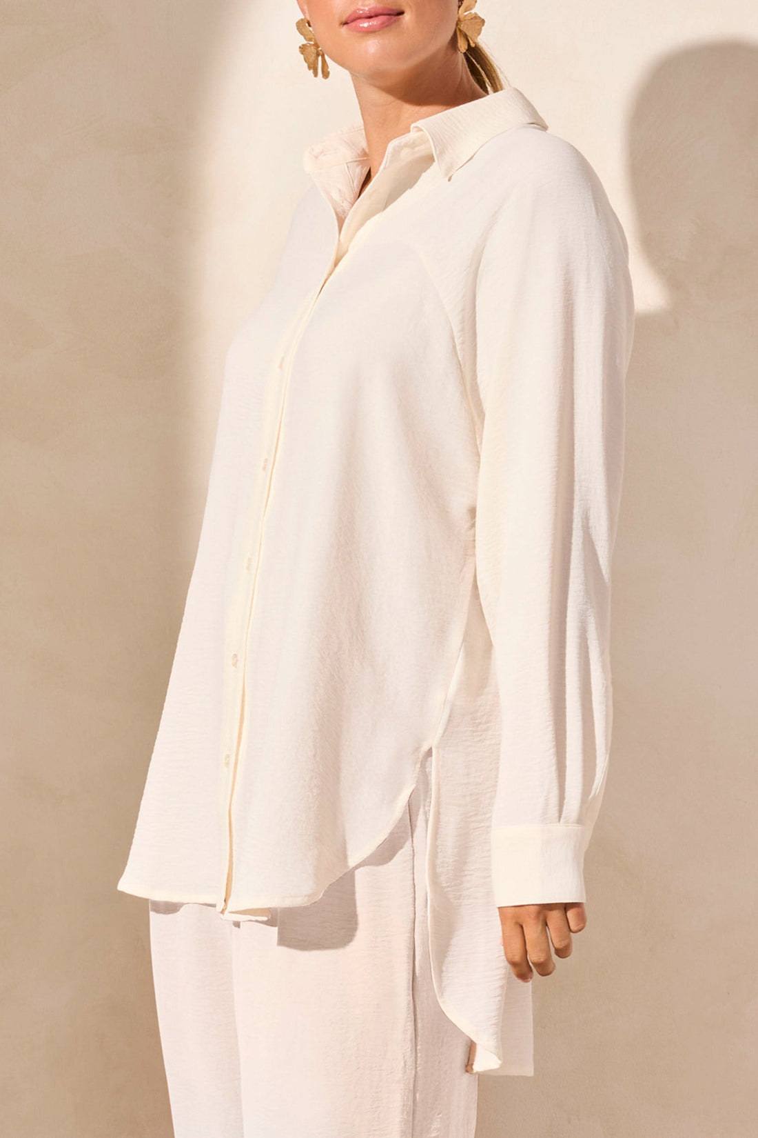 A person wearing the Tribal FLOWY RAGLAN SLEEVE SHIRT in brown, paired with loose-fitting pants, stands against a plain light-colored background.